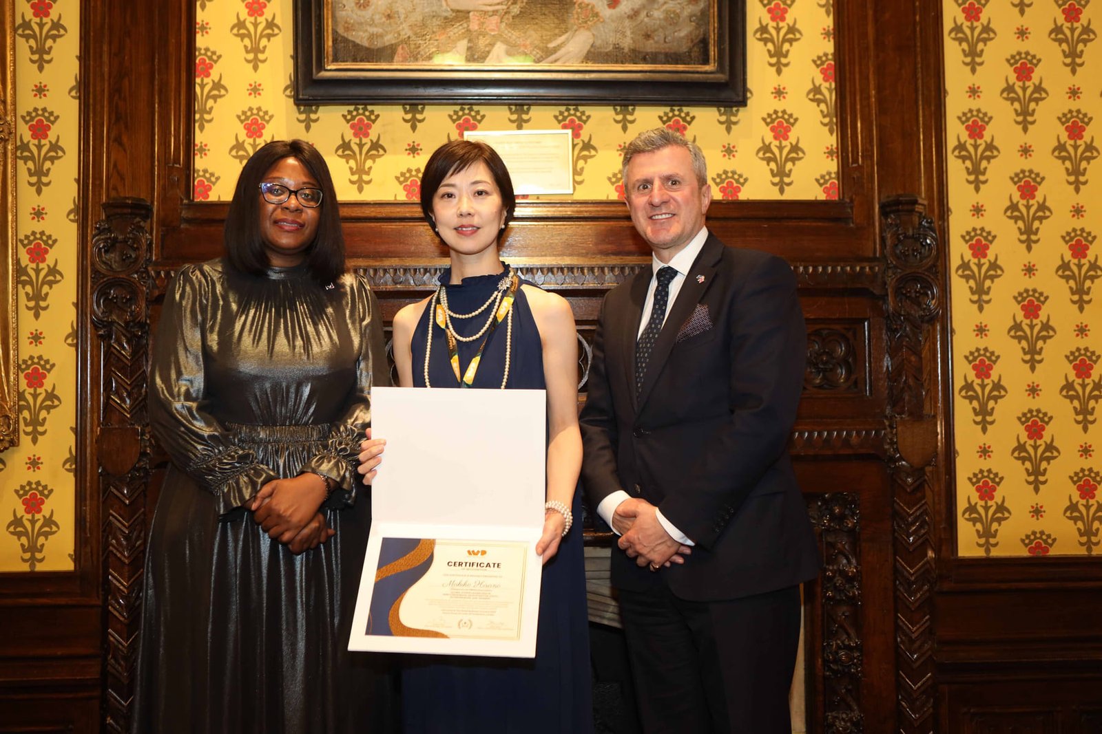 An honoree receives her certificate from the hosts at the London ceremony